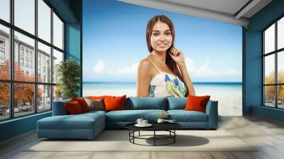 Beautiful young woman on the beach. Blurry beach and ocean background. Wall mural