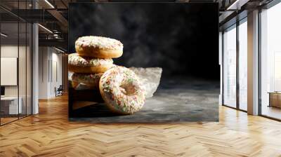 Fresh sweet donuts on dark background and copy space for your decoration  Wall mural