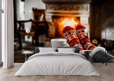 Legs in winter christmas socks on wooden top board with fireplace background in cozy home interior. Wall mural