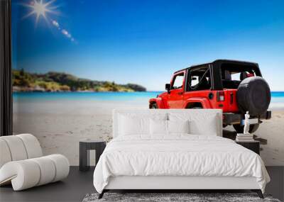 Red summer car on beach and free space for your decoration. Summer sunny day and blue sky.  Wall mural