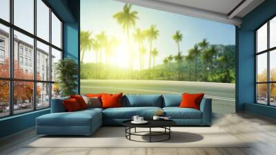 Summer background of road with palms and sunset time  Wall mural