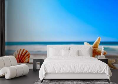 Summer beach and shells with blurred blue sea and sky  Wall mural