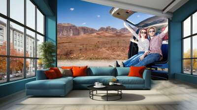 Summer car trip on USA road and two young lovers in big blue car. Free space for your decoration and sun light.  Wall mural