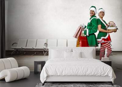 Two Christmas elves in the waiting room. a large wooden floor, white chairs and a white wall with space for your inscription. Christmas advertising background. Wall mural