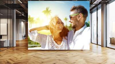 Two young lovers on summer trip and background with palms and sun light.  Wall mural