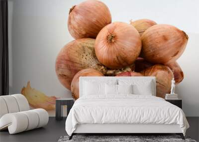 Closeup of a bundle of brown onions on white background Wall mural