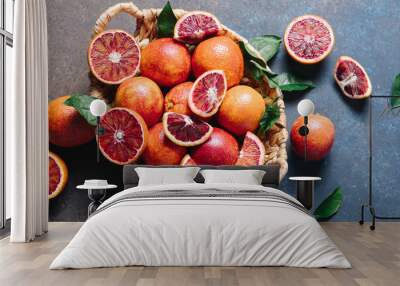 Composition of pile of blood oranges in a basket on a blue table background. Flat lay, top view, copy space Wall mural