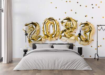 New year 2023 balloon celebration card. Gold foil helium balloon number 2023, party decoration, gold confetti stars on white background. Flat lay, merry christmas, happy holidays concept. Wall mural