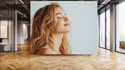 A close up of a woman's face with her eyes closed and long blond hair Wall mural