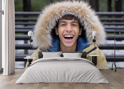 a young man wearing a yellow jacket with a fur hood Wall mural