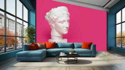 Marble head of young woman, ancient Greek goddess bust isolated on pink background with space for text. Wall mural