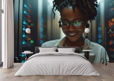 An African American female computer technician appears joyful while using a tablet and working in a server room environment. Wall mural