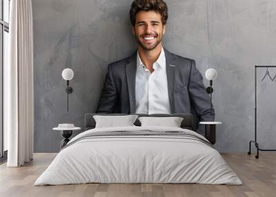 Image of a happy brunette man wearing formal clothes, smiling at the camera with hands in pockets. Wall mural