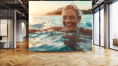 Mature woman swimming in the sea and playing with water Wall mural