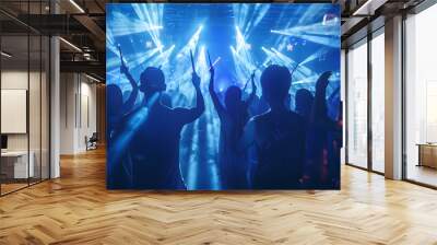 Silhouettes in a nightclub under blue beams of light and young people holding light sabers enjoying a concert concept Wall mural