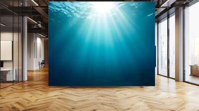 Underwater scene with sunlight beams shining through the deep blue water, creating a serene and tranquil atmosphere. Wall mural