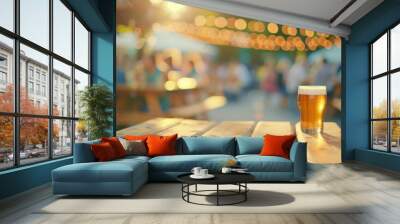 A glass of beer on a wooden table at an outdoor event Wall mural