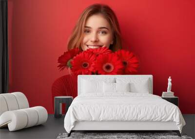 beautiful girl giving bouquet of gerberas with cheerful expression on red background  Wall mural