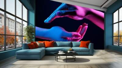 Two hands showing a sale advertisement copy space and black background with burst of colors with colorful glitter style Wall mural