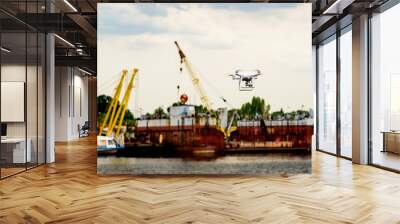 Drone with camera flying on container cargo ship at shipping port. double exposure Wall mural