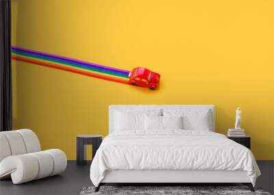 red toy car, rainbow ribbon flag trail road, yellow background. June gay parade, proud month, coming out day, human rights and tolerance concept. Minimal pop art composition. Flat lay, top view Wall mural