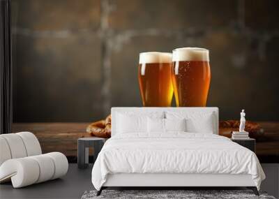 Two glasses of golden beer with a frothy head, accompanied by pretzels, set on a rustic wooden surface. Perfect for promotions in bars, breweries, and food events. Wall mural