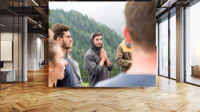 young group of men and women stand in a circle and prepare to have a group prayer outdoors Wall mural