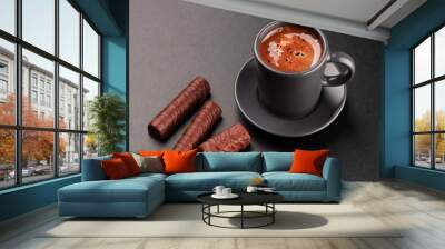 Cup of coffee and chocolates on dark background Wall mural