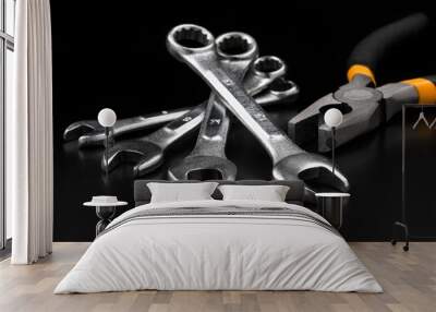 Spanner set and pliers on black background Wall mural