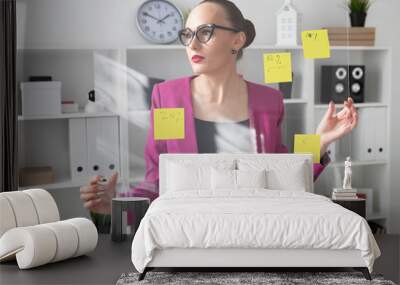 A girl in a pink jacket holds a board with stickers. Office work Wall mural