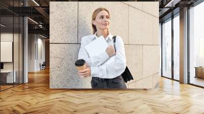 A pretty young woman with white hair dressed in a white shirt and black jeans goes down into an underground passage Wall mural