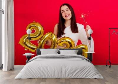 Christmas Holiday Concert - A young woman in a white dress holding the numbers 2022 and sparklers Wall mural