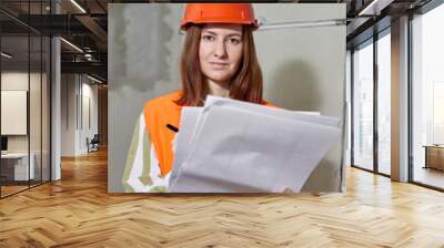 The designer, a woman dressed in an orange vest and hard hat, brought with her drawings for the layout of the apartment Wall mural