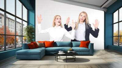 Two beautiful blondes in business suits are happy that the working day is over Wall mural