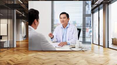 Asian doctor consults young patient Wall mural