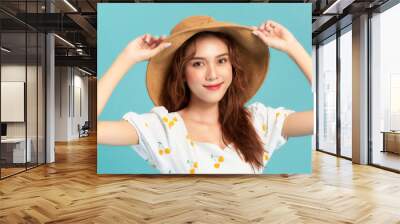 beautiful attractive stylish woman in straw hat posing on blue background Wall mural