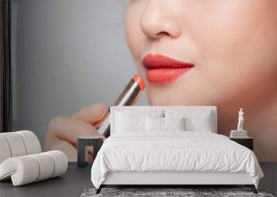 Beautiful young woman putting lipstick on lips Wall mural