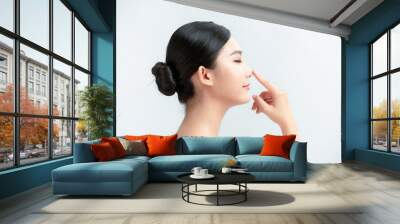 beauty skincare woman smile happily and pointing her nose on white background Wall mural