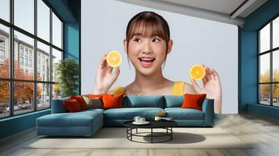 Cheerful feminine girl, natural clear skin, girl with two lemon slices, isolated on a white background Wall mural