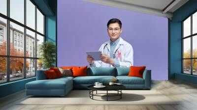 Doctor with pink ribbon on color background. Breast cancer awareness concept Wall mural