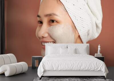 Emotional portrait of a happy and positive beautiful nude young woman with a clay cosmetic mask on her face Wall mural