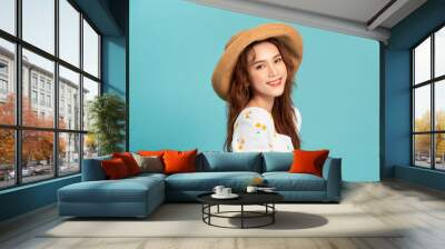 Fashion portrait pretty woman in straw summer hat over colorful blue background Wall mural