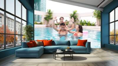 Happy family in swimming pool. Summer holidays and vacation concept Wall mural