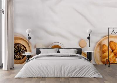 Morning breakfast with chocolate donuts and cup of coffee with cream on light silk background Wall mural