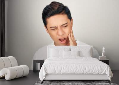 Portrait of fat Asian man use his hand touch his cheek, feeling painful from toothache. Oral health concept. Wall mural