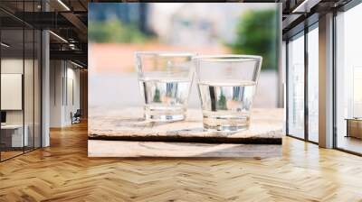 Two glasses of water on table on wooden background Wall mural