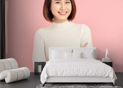 Young Asian woman wearing  sweater standing over isolated pink background happy face smiling with crossed arms looking at the camera. Positive person. Wall mural