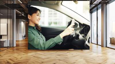 Young beautiful woman driving her car Wall mural