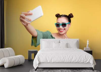 Young cheerful attractive asian woman taking selfies with smile. Wall mural