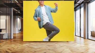 Young man very happy and excited doing winner gesture with arms raised, Wall mural